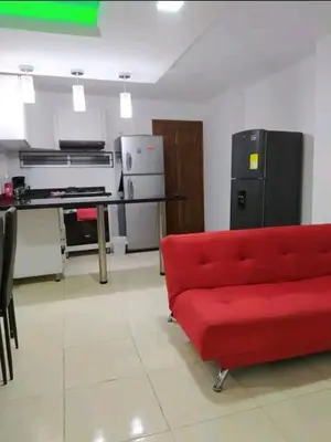 a living room with a red couch and a kitchen at excelente ubicación Milán in Manizales