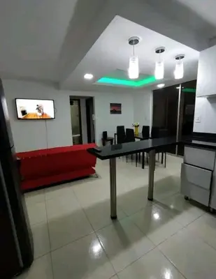 a conference room with a table and a red couch at excelente ubicación Milán in Manizales