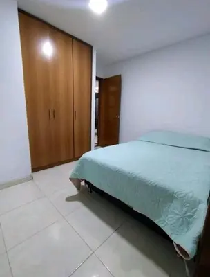 a bedroom with a bed and a wooden cabinet at excelente ubicación Milán in Manizales