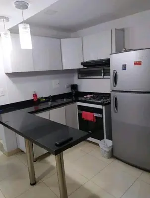 a kitchen with a refrigerator and a table in it at excelente ubicación Milán in Manizales