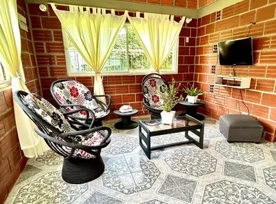 a living room with three chairs and a television at Almalu Finca in Filadelfia