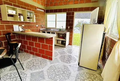 a kitchen with a refrigerator and a brick wall at Almalu Finca in Filadelfia