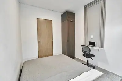 a bedroom with a bed and a desk and a chair at El Poblado 4 Bedrooms 2 Baths Private Terrace in Medellín
