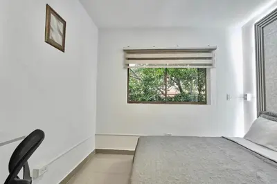 a white bedroom with a bed and a window at El Poblado 4 Bedrooms 2 Baths Private Terrace in Medellín