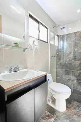 a bathroom with a white sink and a toilet at El Poblado 4 Bedrooms 2 Baths Private Terrace in Medellín
