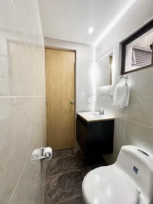 a bathroom with a white toilet and a sink at El Poblado 4 Bedrooms 2 Baths Private Terrace in Medellín