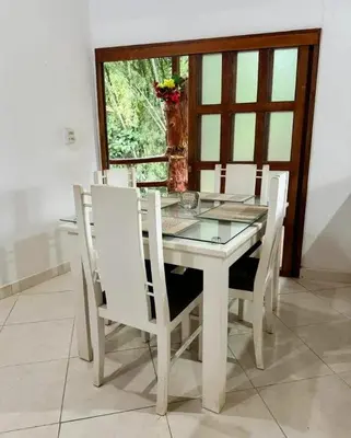 a white dining room table with white chairs and a window at Los micos in San Rafael