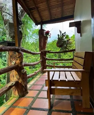 a wooden bench sitting on a porch with a fence at Los micos in San Rafael