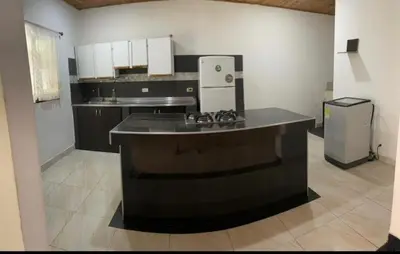 a kitchen with a black counter and a refrigerator at Los micos in San Rafael