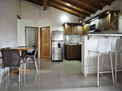 a kitchen with a refrigerator and a table and chairs at Apartamento central en Guatape - 2 habitaciones - 2 baños - Ideal familias in Guatapé