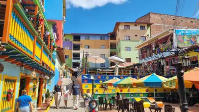 a group of people walking down a street with buildings at Apartamento central en Guatape - 2 habitaciones - 2 baños - Ideal familias in Guatapé