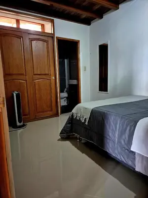 a bedroom with a bed and a wooden cabinet at Apartamento central en Guatape - 2 habitaciones - 2 baños - Ideal familias in Guatapé
