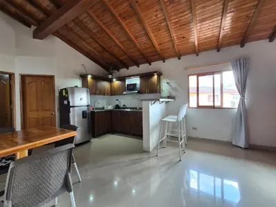 a kitchen with a refrigerator and a table and chairs at Apartamento central en Guatape - 2 habitaciones - 2 baños - Ideal familias in Guatapé