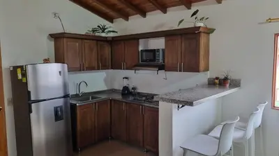 a kitchen with wooden cabinets and a refrigerator at Apartamento central en Guatape - 2 habitaciones - 2 baños - Ideal familias in Guatapé