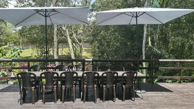 a table with black chairs and white umbrellas at VILLA DOLLS PRIVADA CON SAUNA, PISCINA Y MAs in Rionegro