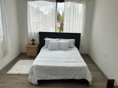 a bedroom with a bed with white sheets and a window at VILLA DOLLS PRIVADA CON SAUNA, PISCINA Y MAs in Rionegro