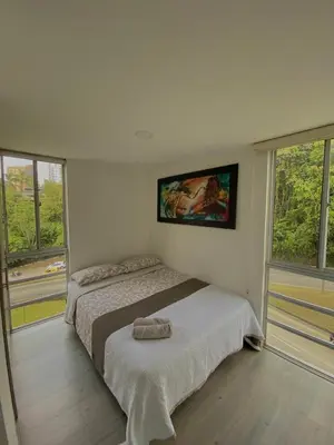 a bedroom with a bed and two windows at Apartamento en Manizales in Manizales