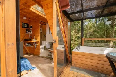 a large bathroom with a tub and a large window at Glamping, Jacuzzi, Malla Catamarán y Desayuno en Santa Elena in Medellín