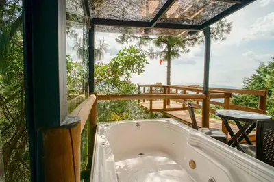 a bath tub in a room with a balcony at Glamping, Jacuzzi, Malla Catamarán y Desayuno en Santa Elena in Medellín