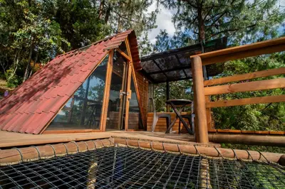 a house with a roof on top of a pool at Glamping, Jacuzzi, Malla Catamarán y Desayuno en Santa Elena in Medellín