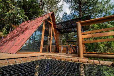 a house with a roof on top of a pool at Glamping, Jacuzzi, Malla Catamarán y Desayuno en Santa Elena in Medellín