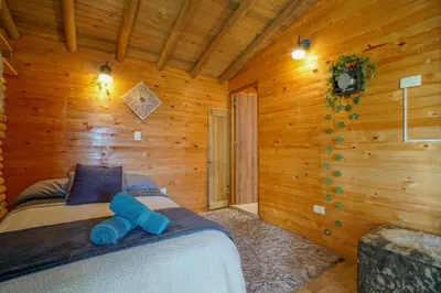 a bedroom with two beds in a log cabin at Cabaña in Medellín
