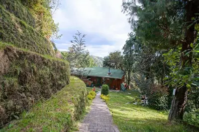 a path in a garden with a house in the background at Cabaña in Medellín