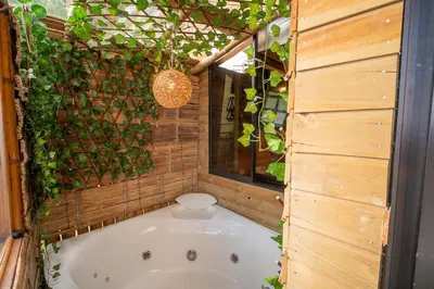 a bathroom with a tub with a green wall at Cabaña in Medellín