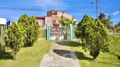 a gate in front of a house with trees at Casa Guatapé in Guatapé