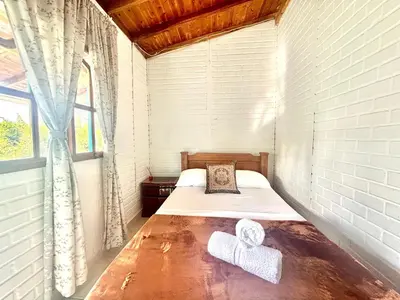 a small bedroom with a bed with towels on it at Casa Guatapé in Guatapé