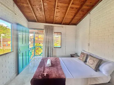 a bedroom with a large bed and a window at Casa Guatapé in Guatapé