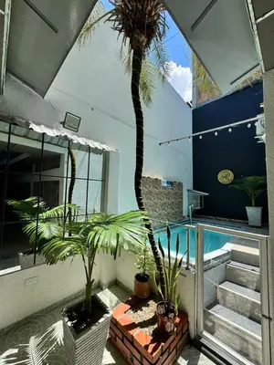 a balcony with a palm tree and a swimming pool at Hotel Regional in La Dorada