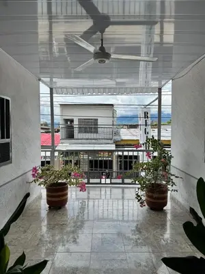 a lobby with potted plants and a ceiling fan at Hotel Regional in La Dorada