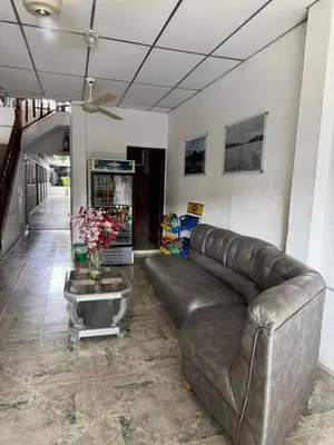 a living room with a leather couch and a table at Hotel Regional in La Dorada