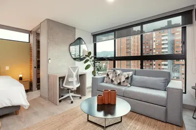a living room with a couch and a bed and a table at Kyux Studios by MOME in Medellín