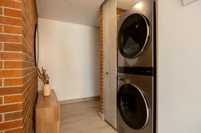 a washer and dryer in a room with a brick wall at Kyux Studios by MOME in Medellín