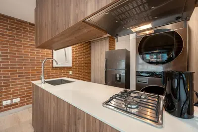 a kitchen with a stove and a microwave at Kyux Studios by MOME in Medellín