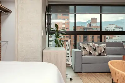 a living room with a couch and a window at Kyux Studios by MOME in Medellín