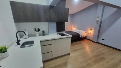 a kitchen with a sink and a room with a bed at Casa 1982 in Manizales