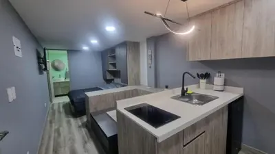 a kitchen with a sink and a living room at Casa 1982 in Manizales