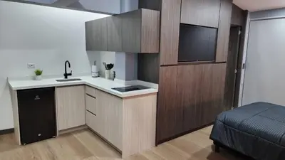 a kitchen with wooden cabinets and a flat screen tv at Casa 1982 in Manizales