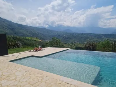 a dog laying next to a swimming pool at Casa Elixir Sopetrán in Sopetran