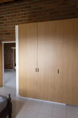 a large wooden cabinet in a room with a brick wall at Finca campestre de 2 pisos en Guarne in Guarne