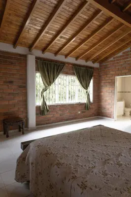 a bedroom with a large bed and two windows at Finca campestre de 2 pisos en Guarne in Guarne