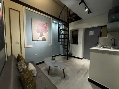 a living room with a couch and a table at apartamento duplex la 70 estadio laurles in Medellín