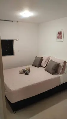 a large bed in a white room with avertisementatronatronatron at Apartment in Envigado with a pool in Envigado
