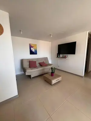 a living room with a couch and a flat screen tv at Apartment in Envigado with a pool in Envigado