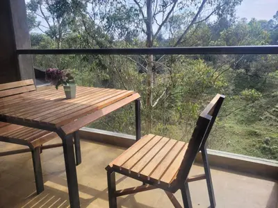 a wooden table and a chair on a balcony at Aparta Suite Hotel Rioverde Aeropuerto JMC in Rionegro