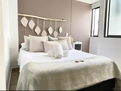 a bedroom with a large white bed with towels on it at Casa palmera cozy loft 301 near everything in Envigado