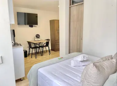 a bedroom with a bed and a table with a television at Casa palmera cozy loft 301 near everything in Envigado